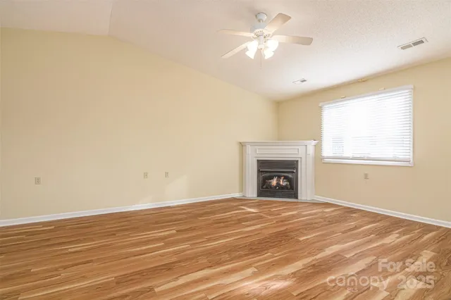 a view of empty room with fan and fireplace