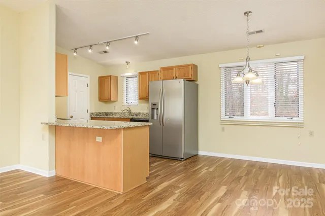 a kitchen with stainless steel appliances granite countertop a refrigerator and a sink