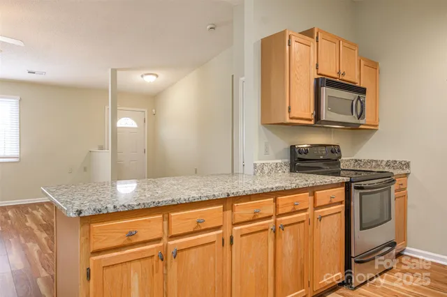 a kitchen with stainless steel appliances granite countertop a sink stove and microwave