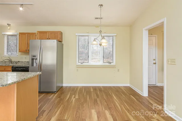 a kitchen with stainless steel appliances granite countertop a refrigerator and a sink