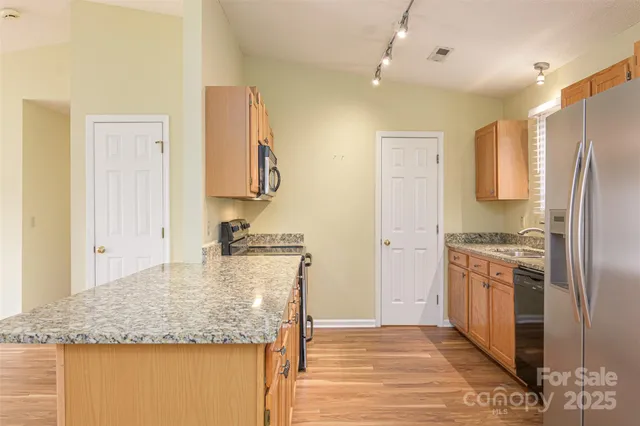 a kitchen with stainless steel appliances granite countertop a sink stove and refrigerator