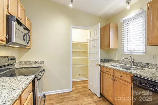 a kitchen with a sink stove top oven and cabinets