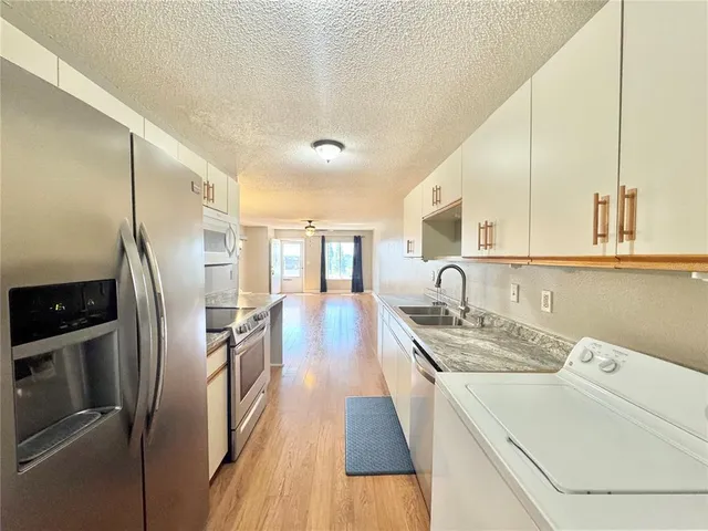 a kitchen with a sink stove and refrigerator