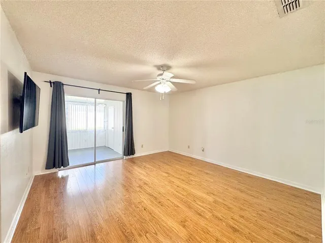a view of a livingroom with a ceiling fan and window