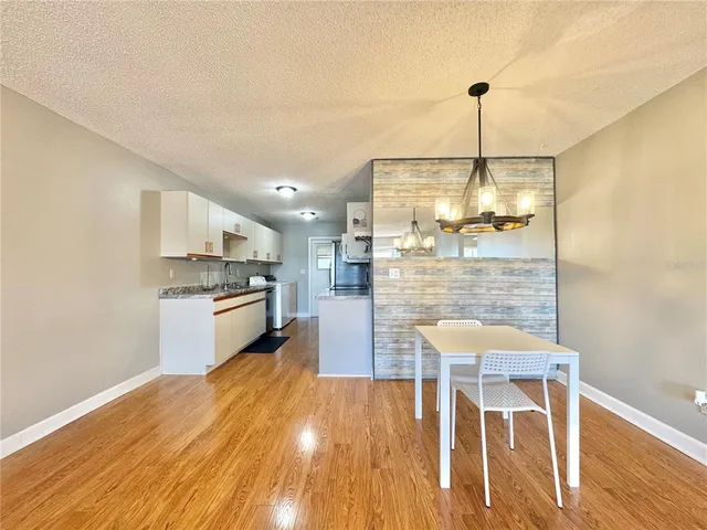 a kitchen with granite countertop white cabinets and stainless steel appliances