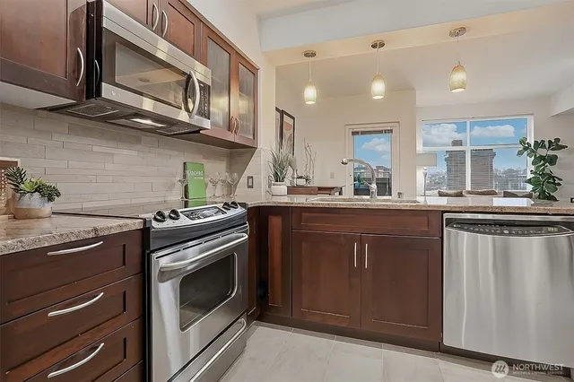 a kitchen with stainless steel appliances granite countertop a sink a stove and cabinets