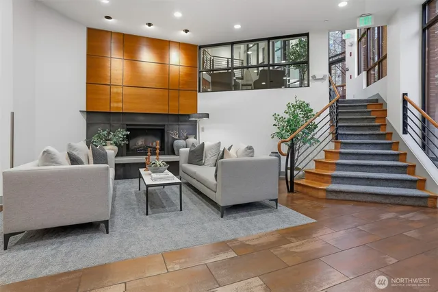 a living room with furniture a flat screen tv and kitchen view