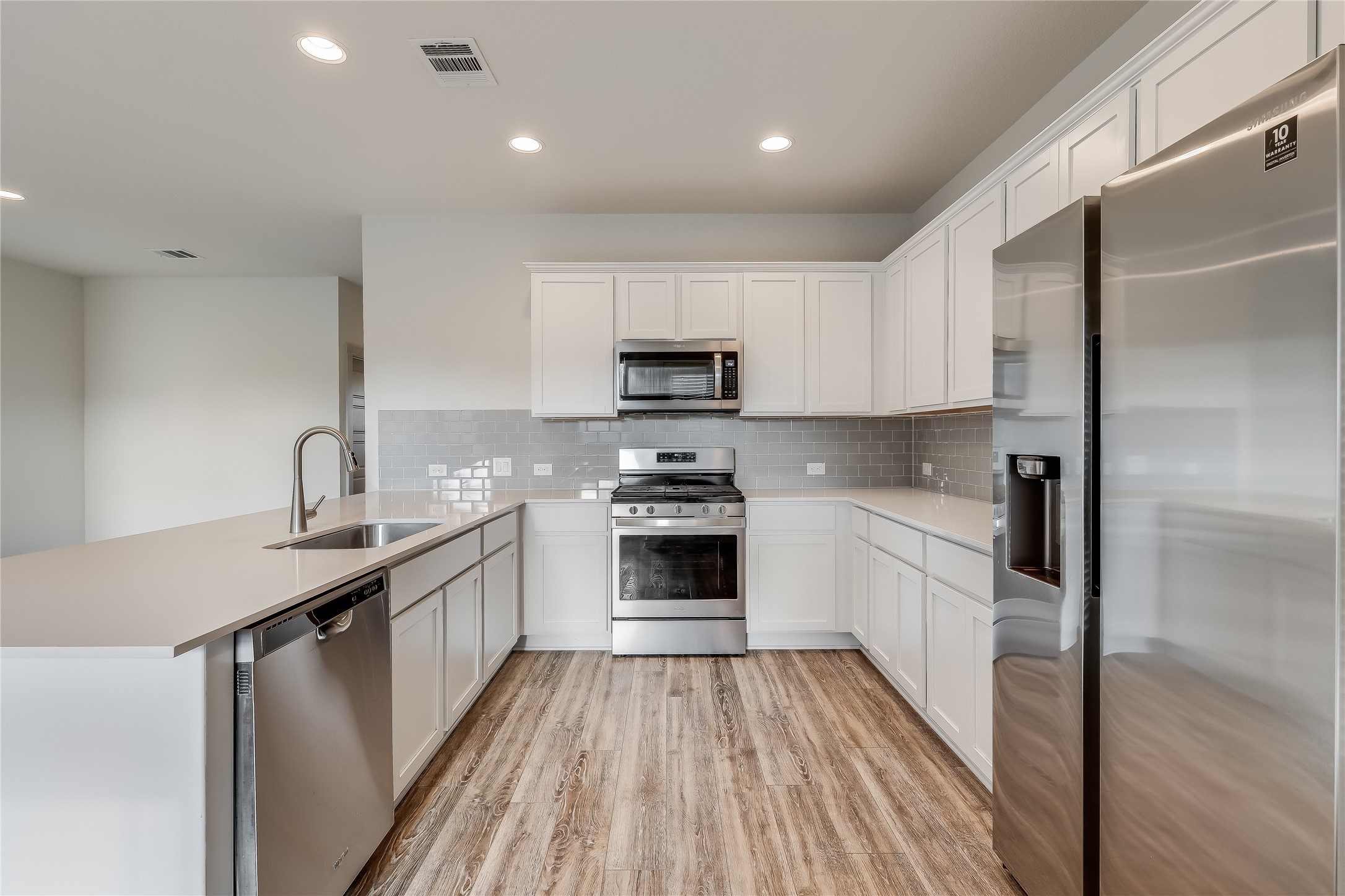 153 Filifera Court Leander, TX 78641 - Photo 3 of 33 a kitchen with granite countertop a sink stove and refrigerator