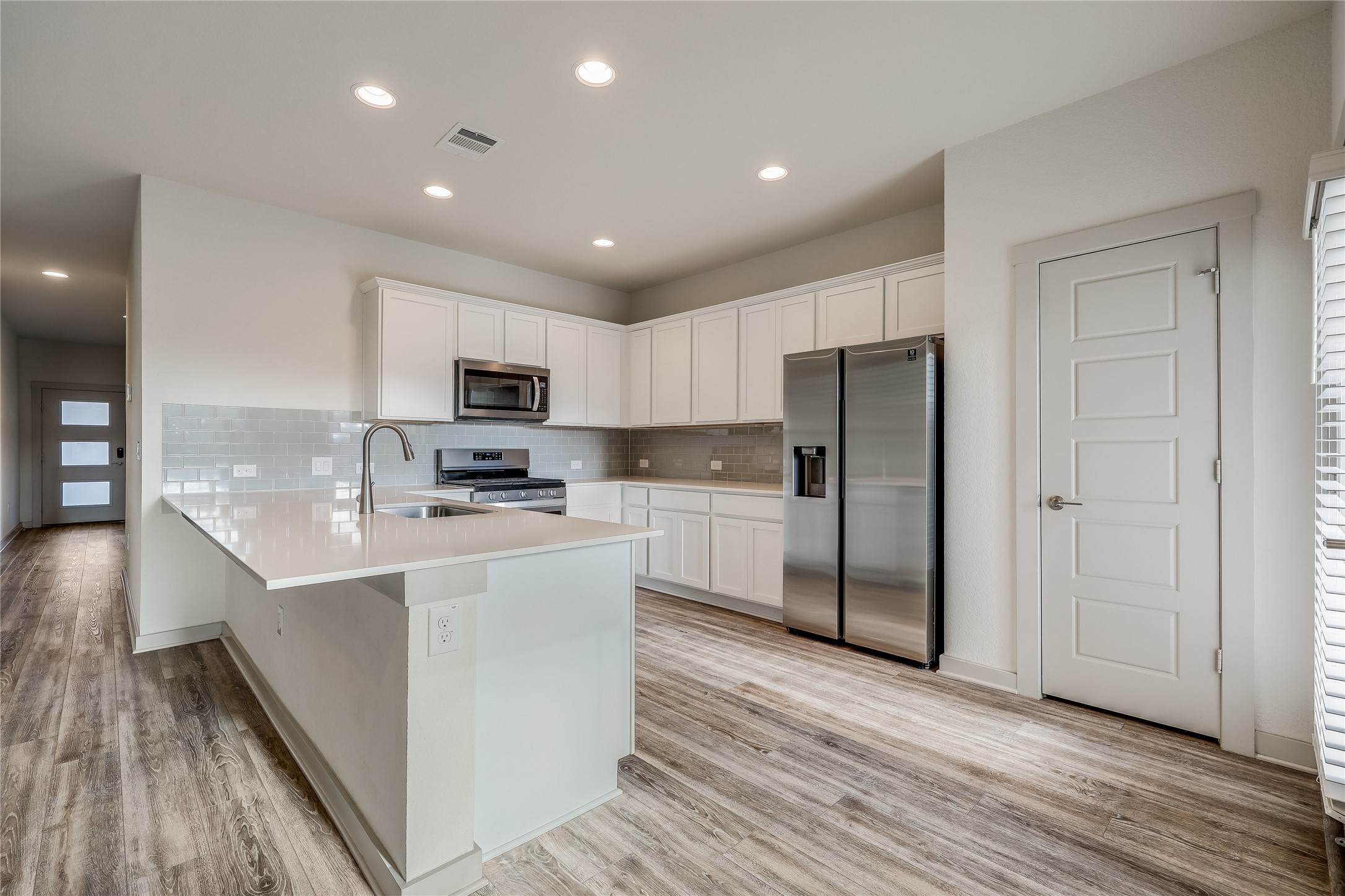 153 Filifera Court Leander, TX 78641 - Photo 4 of 33 a kitchen with stainless steel appliances granite countertop a refrigerator oven a sink dishwasher and a stove with wooden floor
