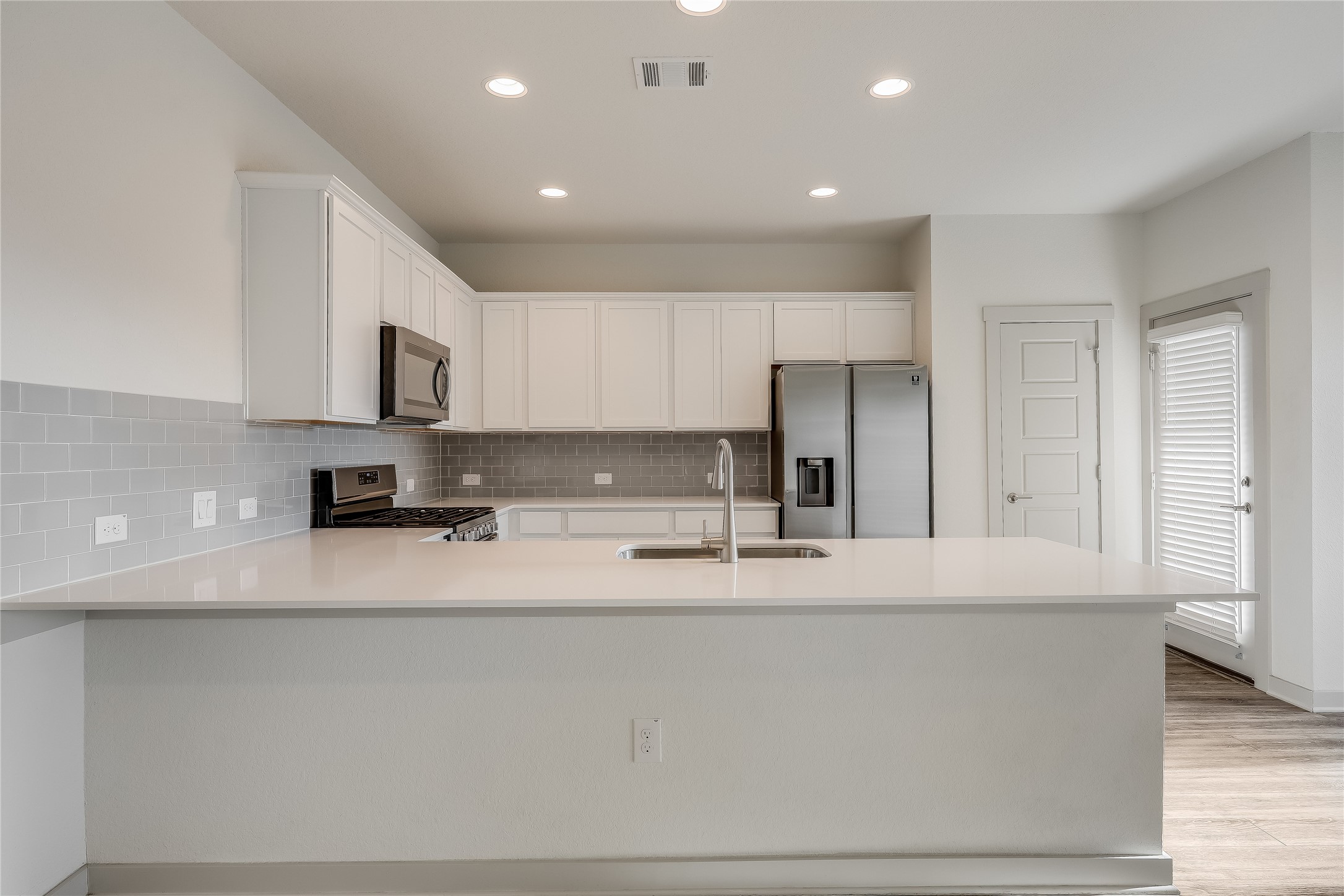 153 Filifera Court Leander, TX 78641 - Photo 5 of 33 a view of a kitchen with kitchen island a sink stainless steel appliances and cabinets