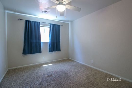 1043 Peg Street Ridgecrest, CA 93555 - Photo 25 of 45 an empty room with windows and fan