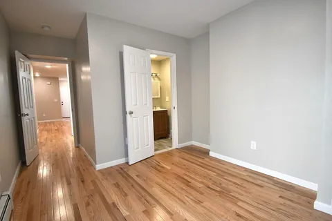 a view of a room with wooden floor and a bathroom