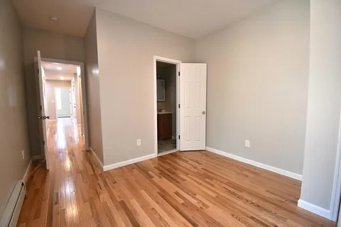 a view of a room with wooden floor and a window