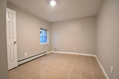 an empty room with white door and windows
