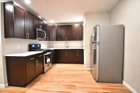a large kitchen with a refrigerator and a sink