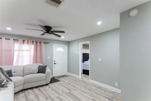 a living room with furniture and a ceiling fan