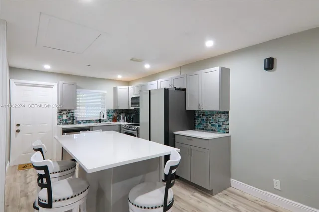 a kitchen with a sink and chairs