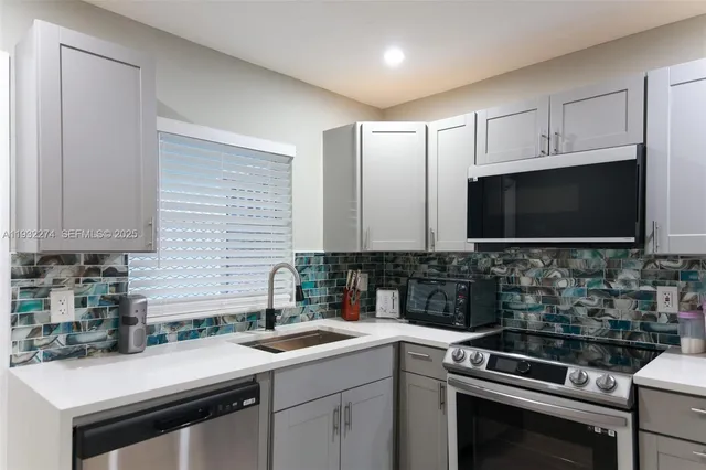 a kitchen with stainless steel appliances a sink stove and microwave