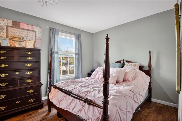 a bedroom with a bed a dresser and a window