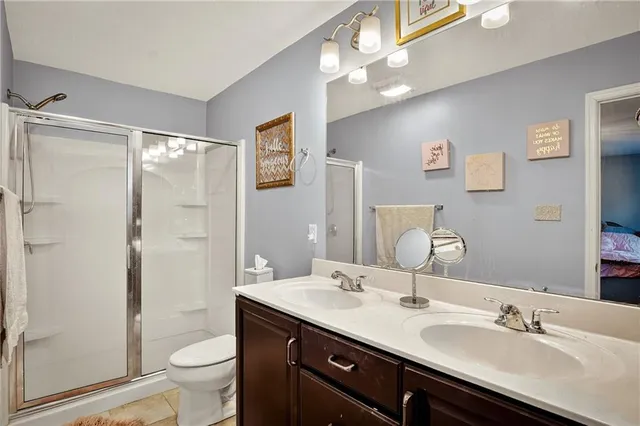 a bathroom with a double vanity sink toilet and shower