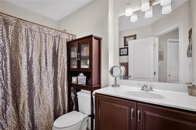 a bathroom with a sink vanity mirror and toilet