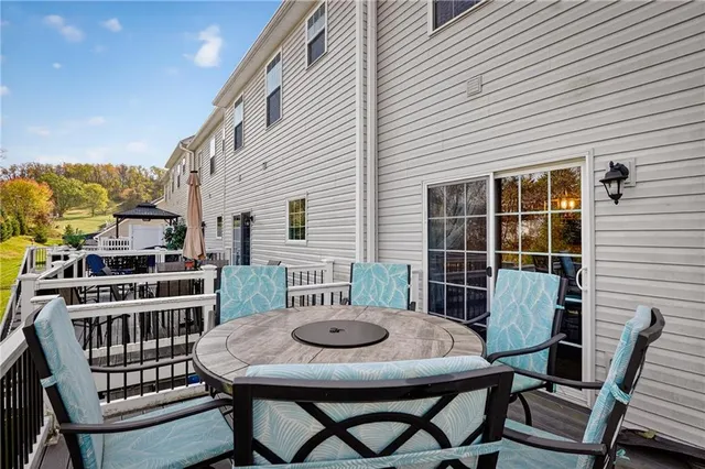 a view of a patio with table and chairs with wooden floor and fence