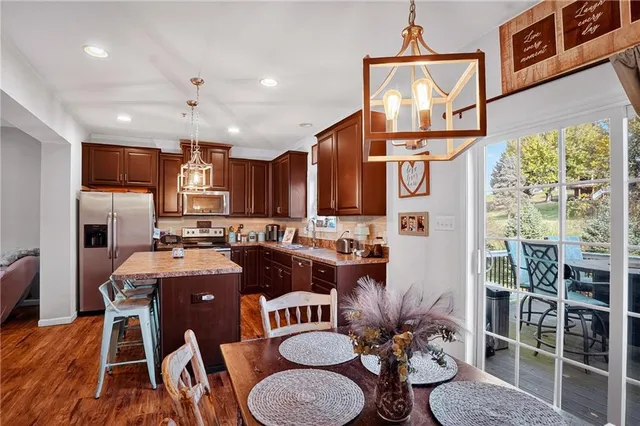 a view of a dining room with furniture a kitchen and chandelier