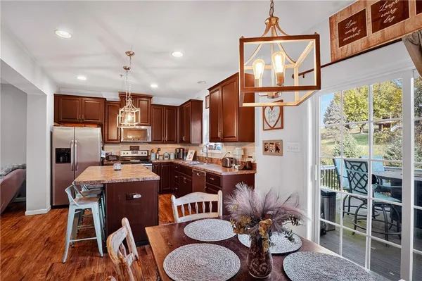 a view of a dining room with furniture a kitchen and chandelier
