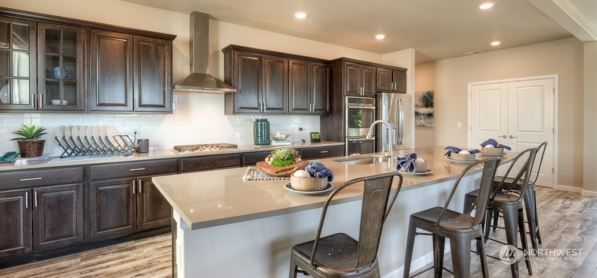 20926 42nd Drive Southeast, Unit 137 Bothell, WA 98021 - Photo 11 of 26 a kitchen with stainless steel appliances granite countertop a table chairs sink and cabinets