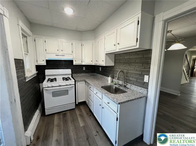 a kitchen with white cabinets sink and white appliances