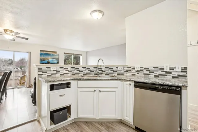 a kitchen with granite countertop a sink stove and cabinets