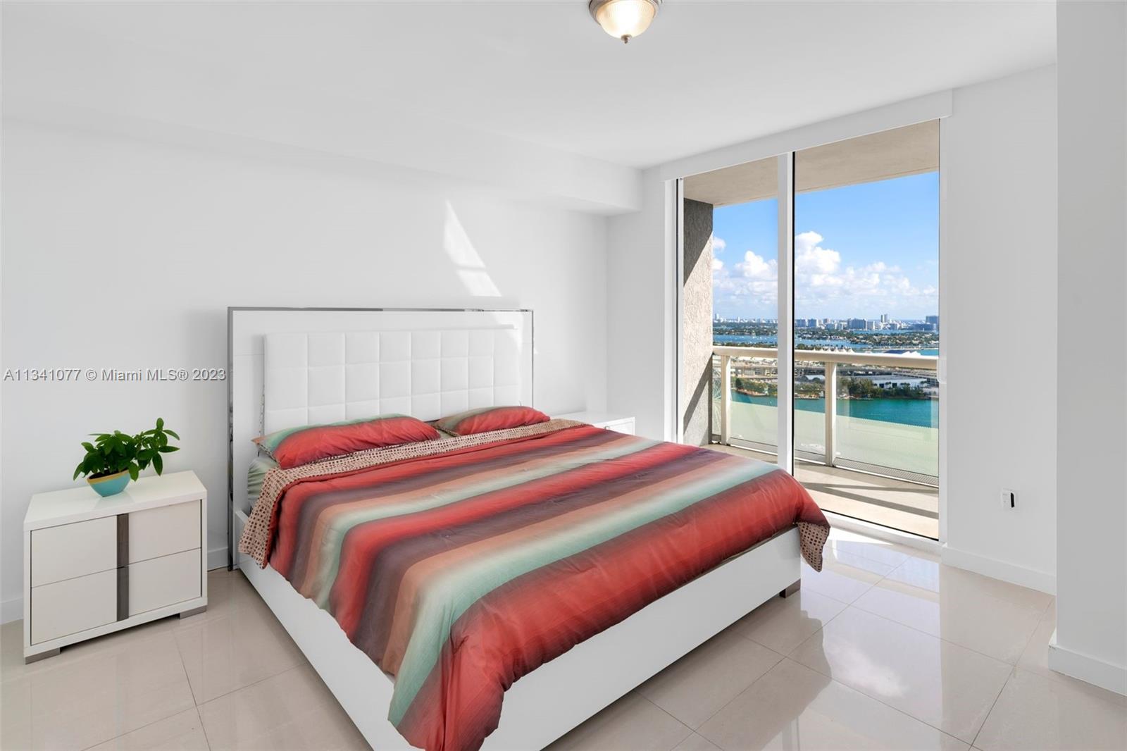 50 Biscayne Boulevard, Unit 3108 Miami, FL 33132 - Photo 14 of 26 a bed sitting in a bedroom next to a window
