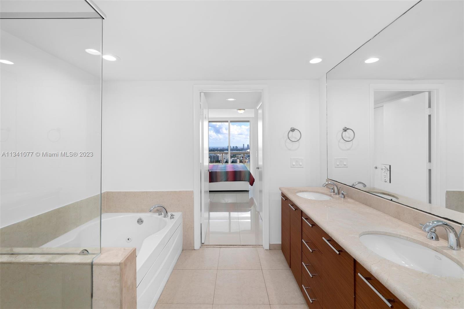 50 Biscayne Boulevard, Unit 3108 Miami, FL 33132 - Photo 17 of 26 a bathroom with a tub sink and mirror