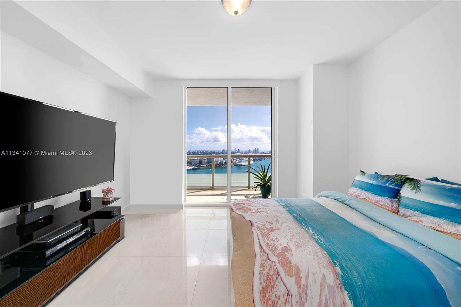 50 Biscayne Boulevard, Unit 3108 Miami, FL 33132 - Photo 20 of 26 a bedroom with a bed and a flat tv screen on the dresser