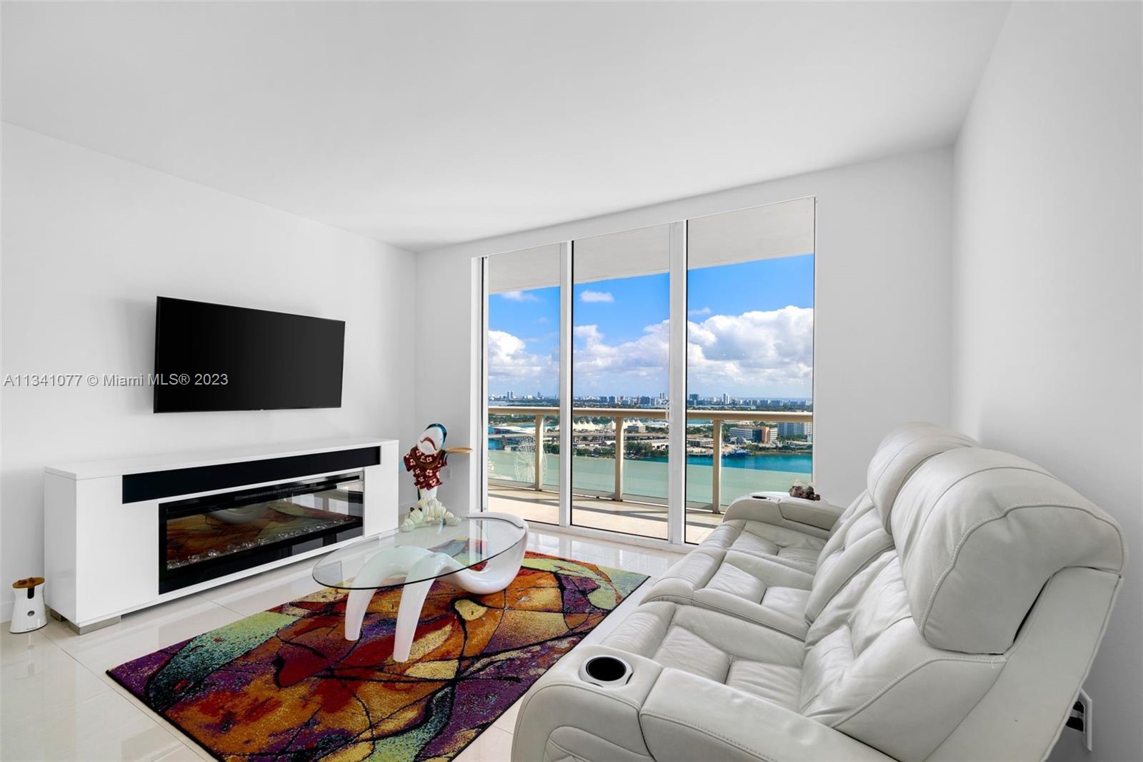 50 Biscayne Boulevard, Unit 3108 Miami, FL 33132 - Photo 7 of 26 a living room with furniture a flat screen tv and a fireplace