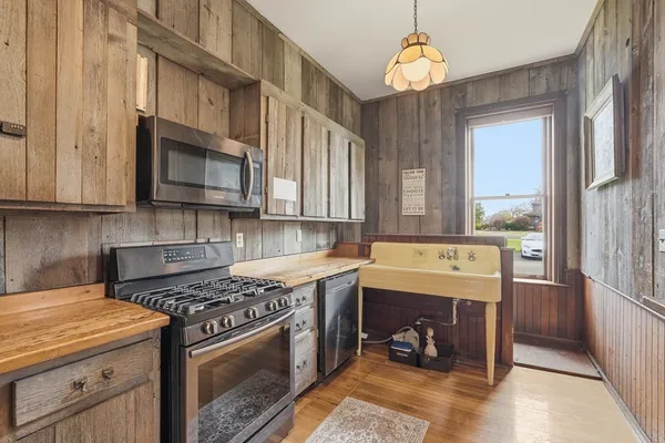 a kitchen with stainless steel appliances granite countertop a stove a sink and a microwave