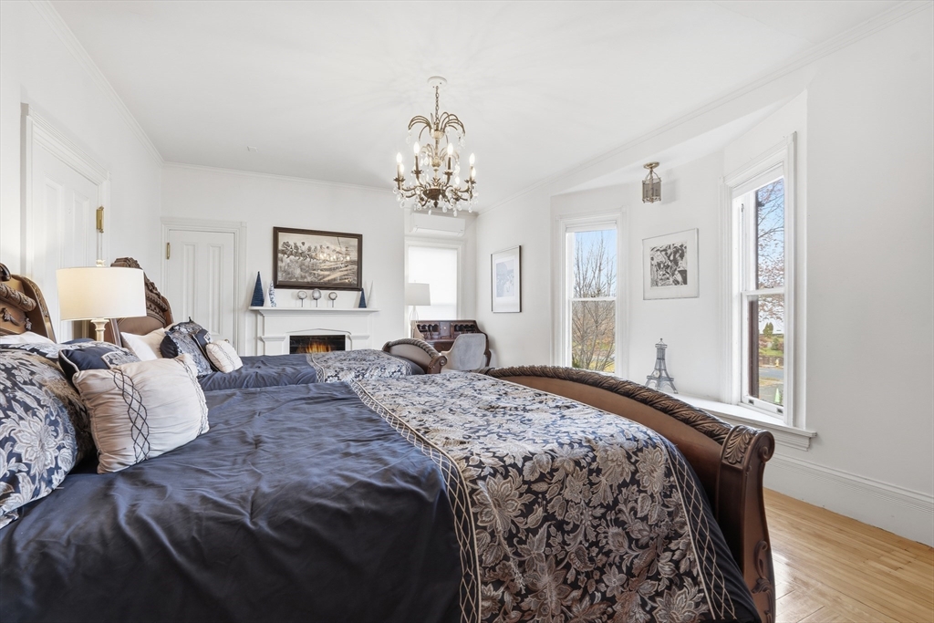 270 Maple Street Springfield, MA 01105 - Photo 31 of 42 a bedroom with a bed and a chandelier