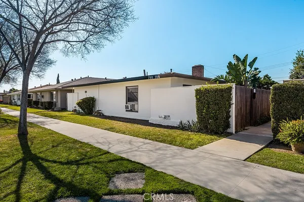 a front view of house with yard and trees around
