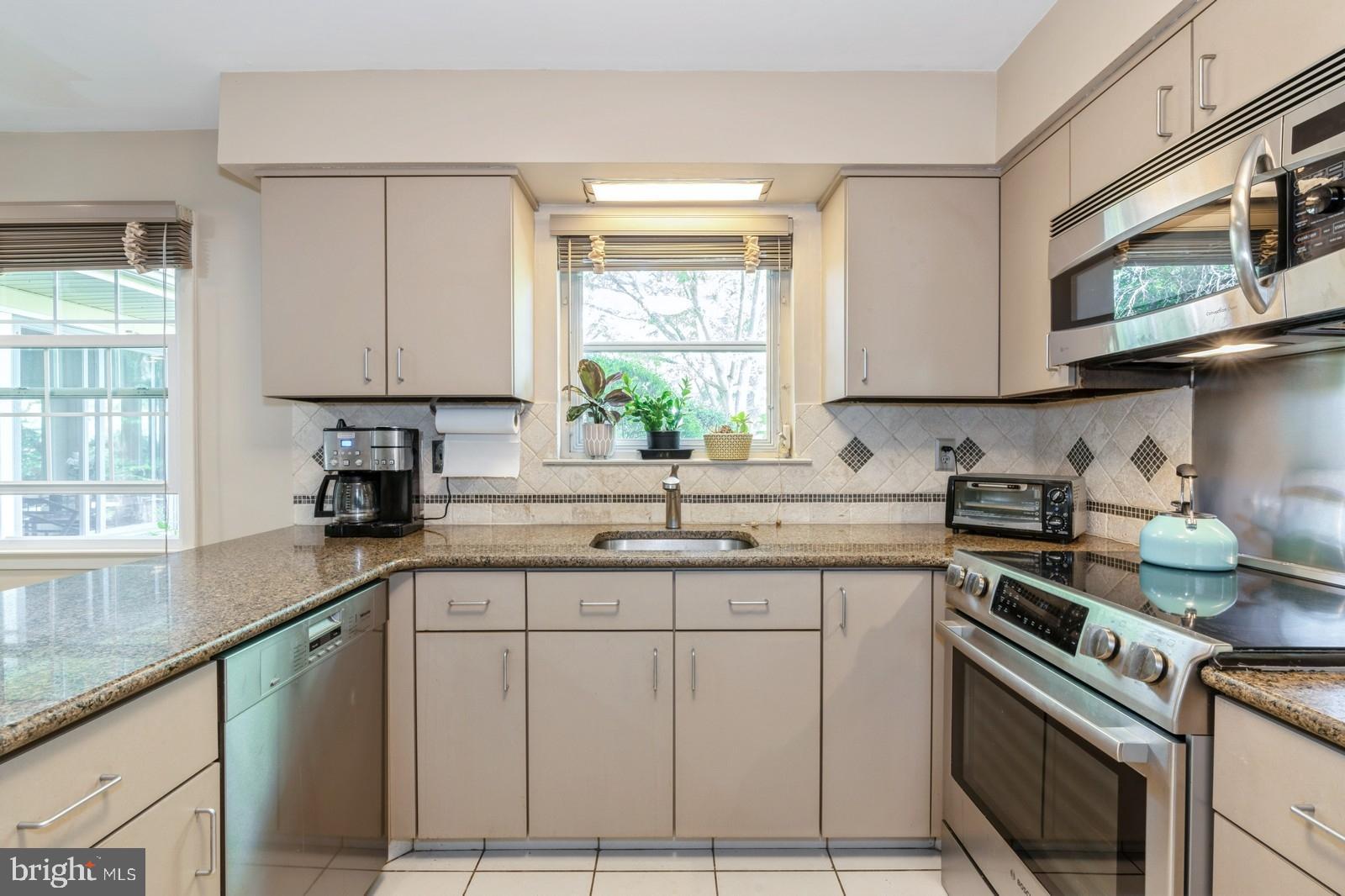 149 Parker Road South Plainsboro, NJ 08536 - Photo 27 of 57 a kitchen with stainless steel appliances granite countertop a sink a stove cabinets and a window