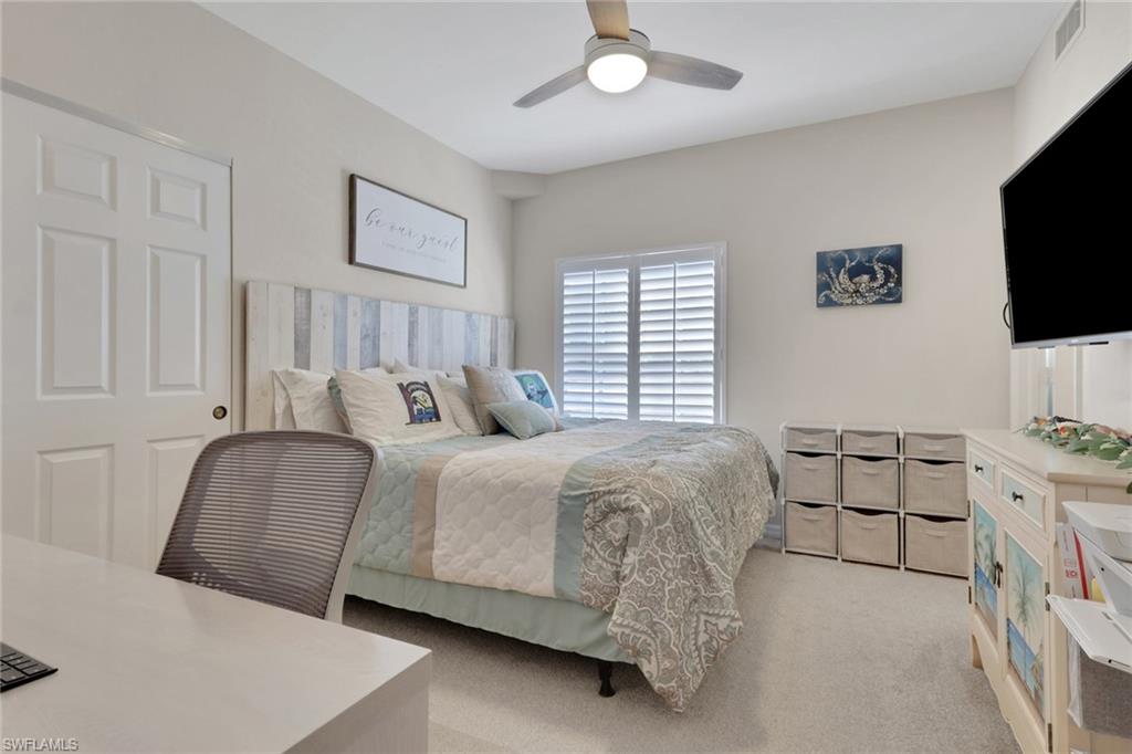 4500 Botanical Pl Circle, Unit 101 Naples, FL 34112 - Photo 16 of 44 a bedroom with a bed and a flat screen tv
