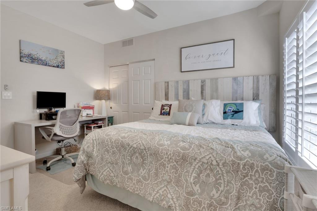 4500 Botanical Pl Circle, Unit 101 Naples, FL 34112 - Photo 17 of 44 a spacious bedroom with a bed and a computer on the desk