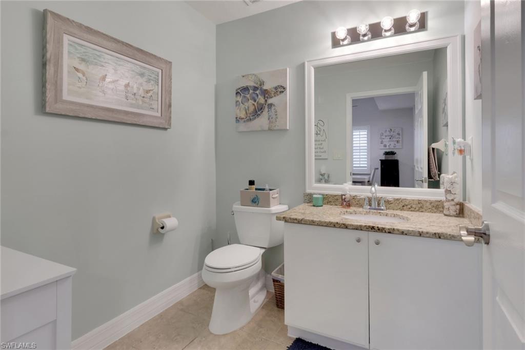 4500 Botanical Pl Circle, Unit 101 Naples, FL 34112 - Photo 22 of 44 a bathroom with a granite countertop toilet sink and mirror