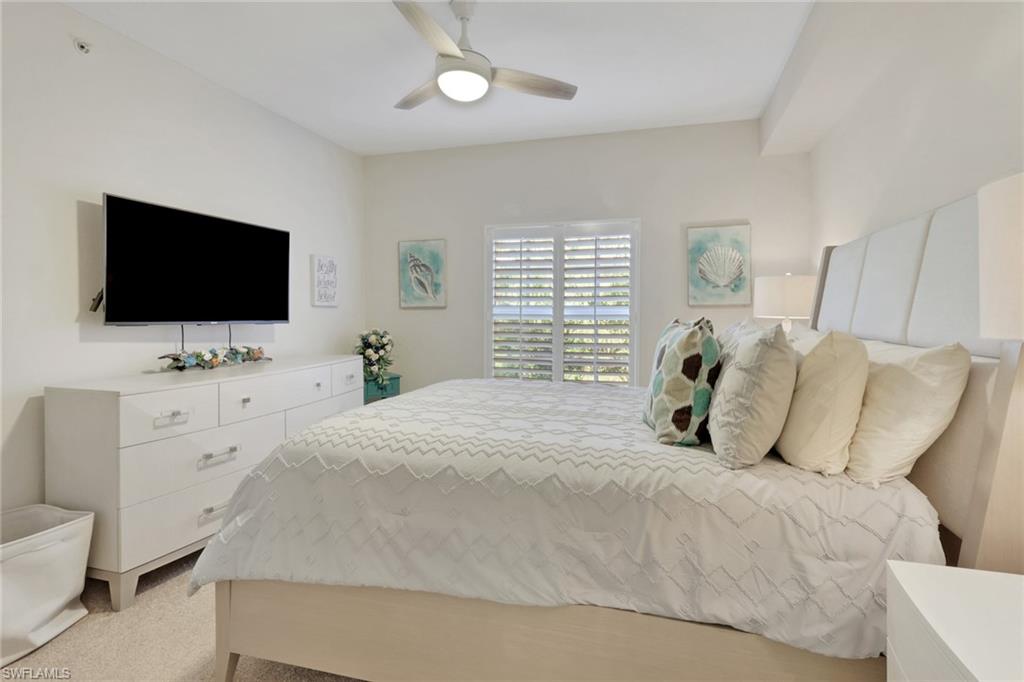 4500 Botanical Pl Circle, Unit 101 Naples, FL 34112 - Photo 24 of 44 a bedroom with a bed and a flat screen tv