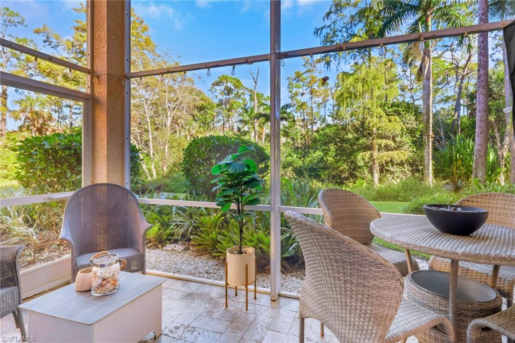 4500 Botanical Pl Circle, Unit 101 Naples, FL 34112 - Photo 27 of 44 a sitting area with furniture and wooden floor