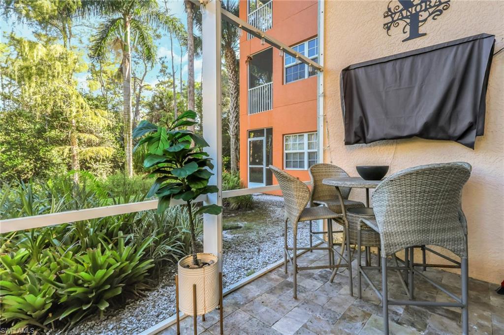 4500 Botanical Pl Circle, Unit 101 Naples, FL 34112 - Photo 29 of 44 a table and chairs in front of a house