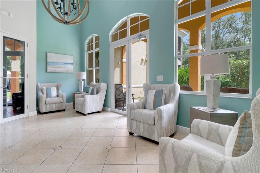 4500 Botanical Pl Circle, Unit 101 Naples, FL 34112 - Photo 32 of 44 a living room with furniture and a large window