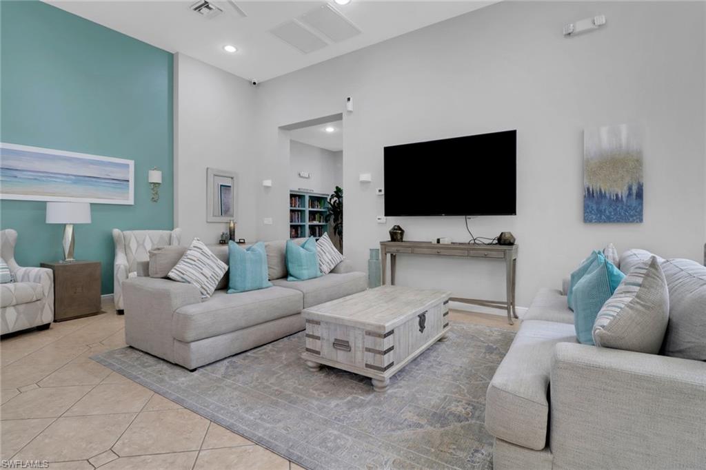 4500 Botanical Pl Circle, Unit 101 Naples, FL 34112 - Photo 33 of 44 a living room with furniture and a flat screen tv