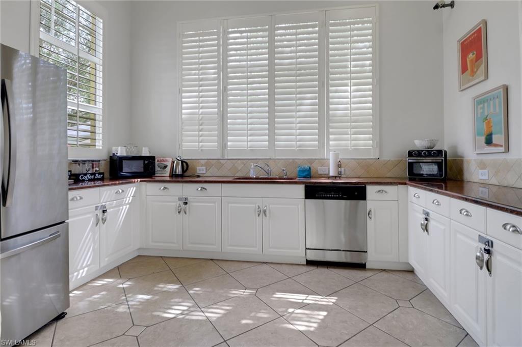4500 Botanical Pl Circle, Unit 101 Naples, FL 34112 - Photo 36 of 44 a kitchen with granite countertop a sink a stove a cabinets and a window