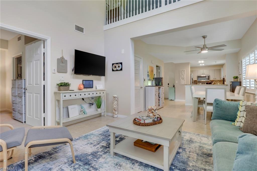 4500 Botanical Pl Circle, Unit 101 Naples, FL 34112 - Photo 5 of 44 a living room with furniture and a flat screen tv