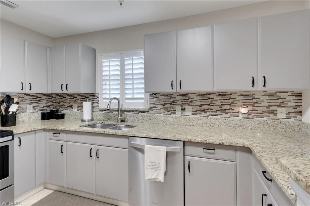 4500 Botanical Pl Circle, Unit 101 Naples, FL 34112 - Photo 8 of 44 a kitchen with stainless steel appliances granite countertop a sink a stove and cabinets